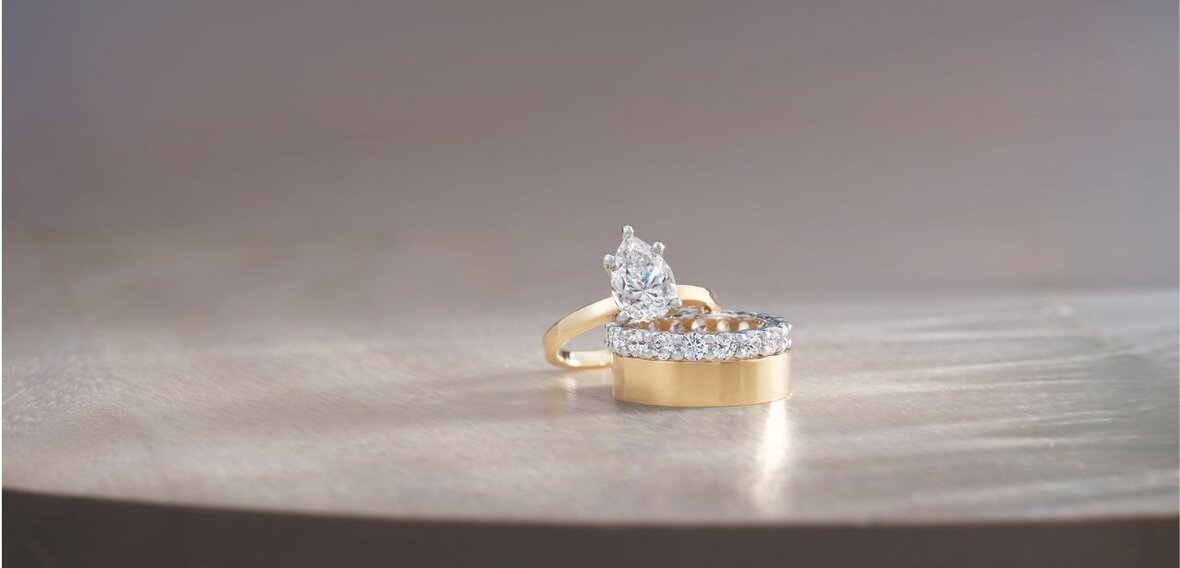 White and yellow gold diamond wedding bands styled on lace fabric, showcasing elegant bridal ring designs by Wedding Bands & Co. in Chicago