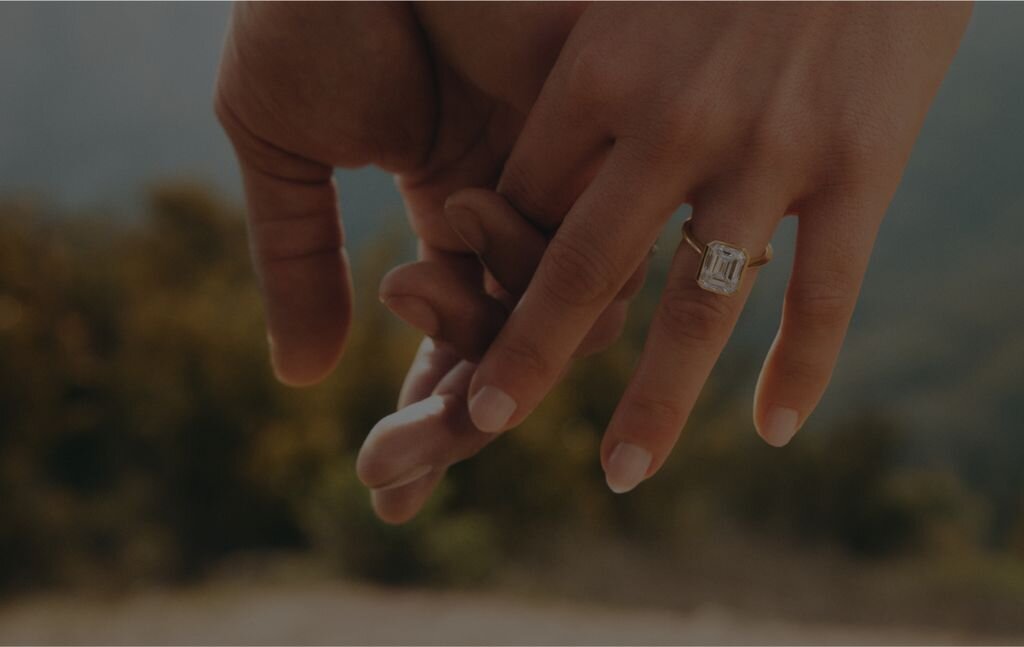 Close-up of hands holding against a dark green background