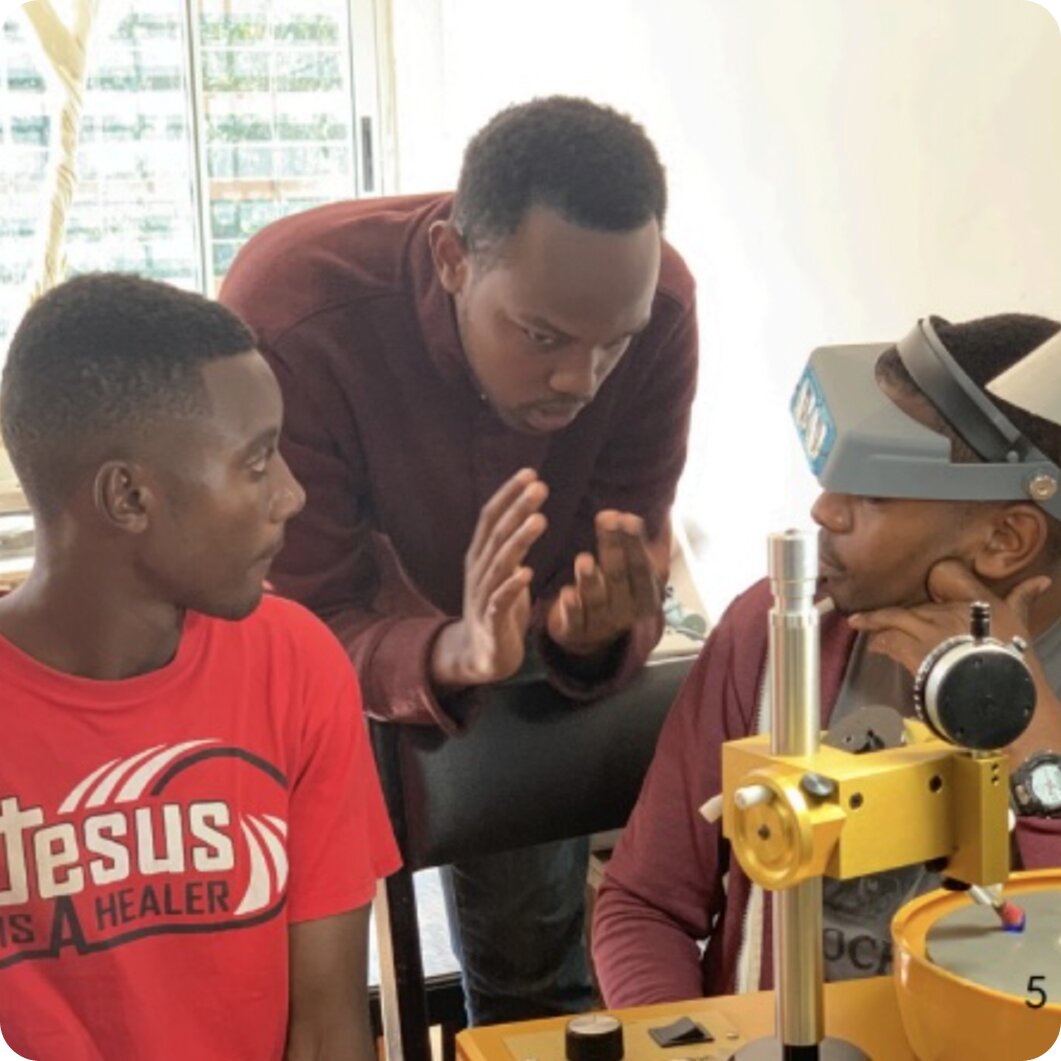 Worker in orange safety vest tending to plants in outdoor setting