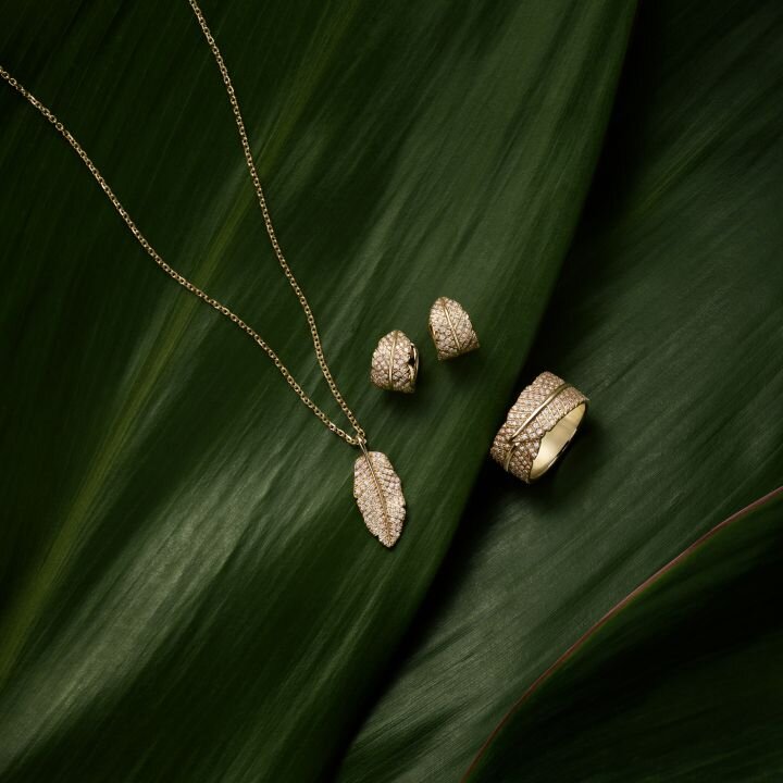 Delicate jewelry pieces on green leaf