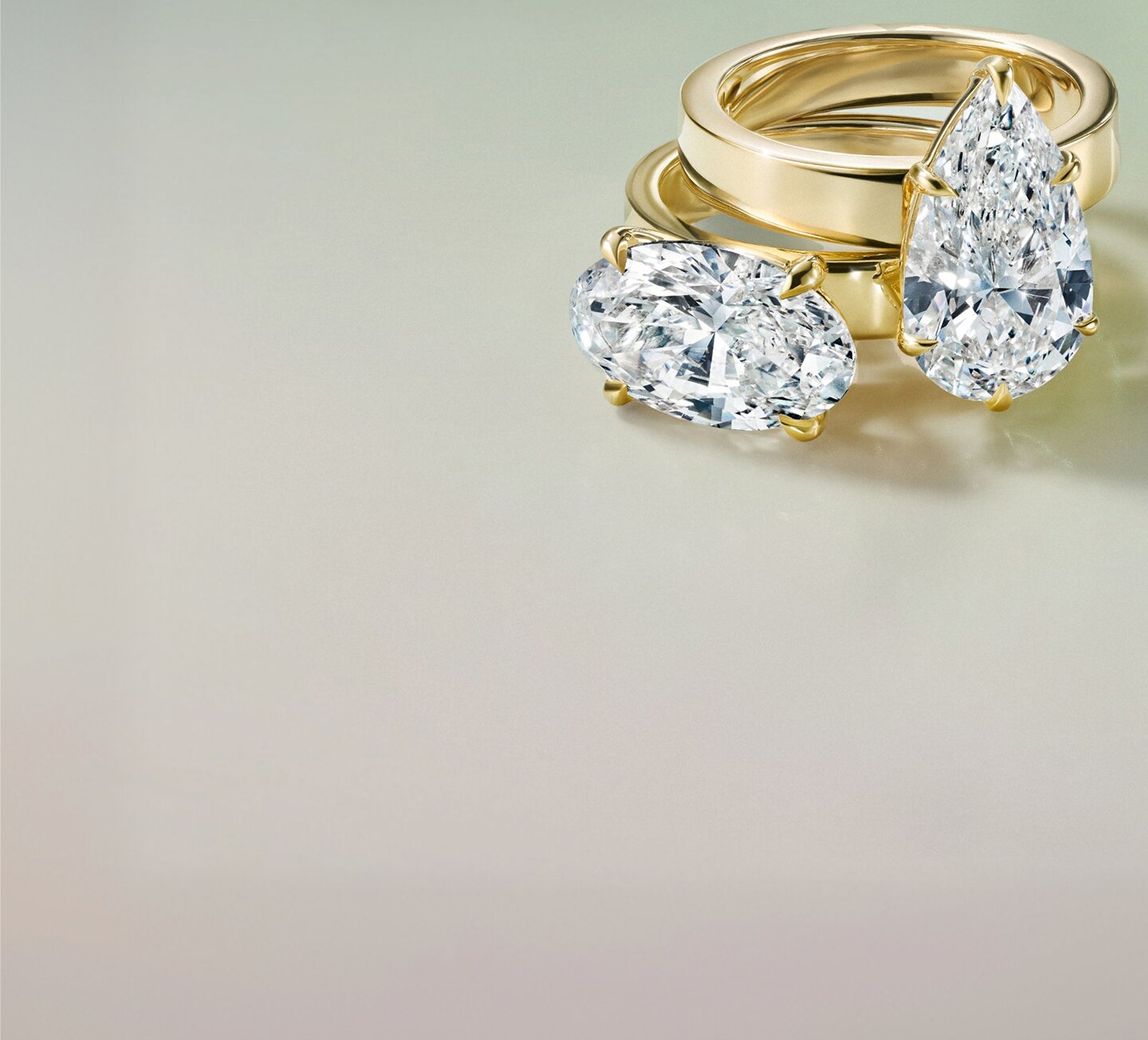 Gold diamond engagement ring against soft white gradient background