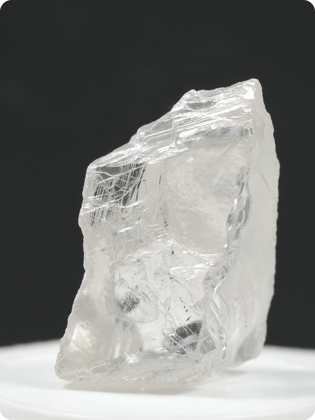 Diamond engagement ring with a large center stone in a detailed setting, photographed against a deep teal background