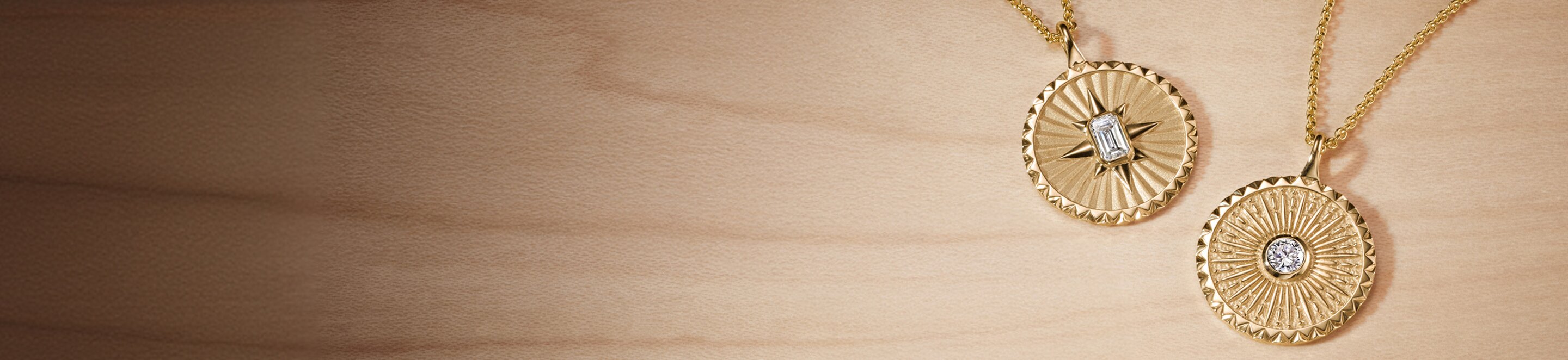 Close-up of multiple gold rings and jewelry bracelets arranged on light surface