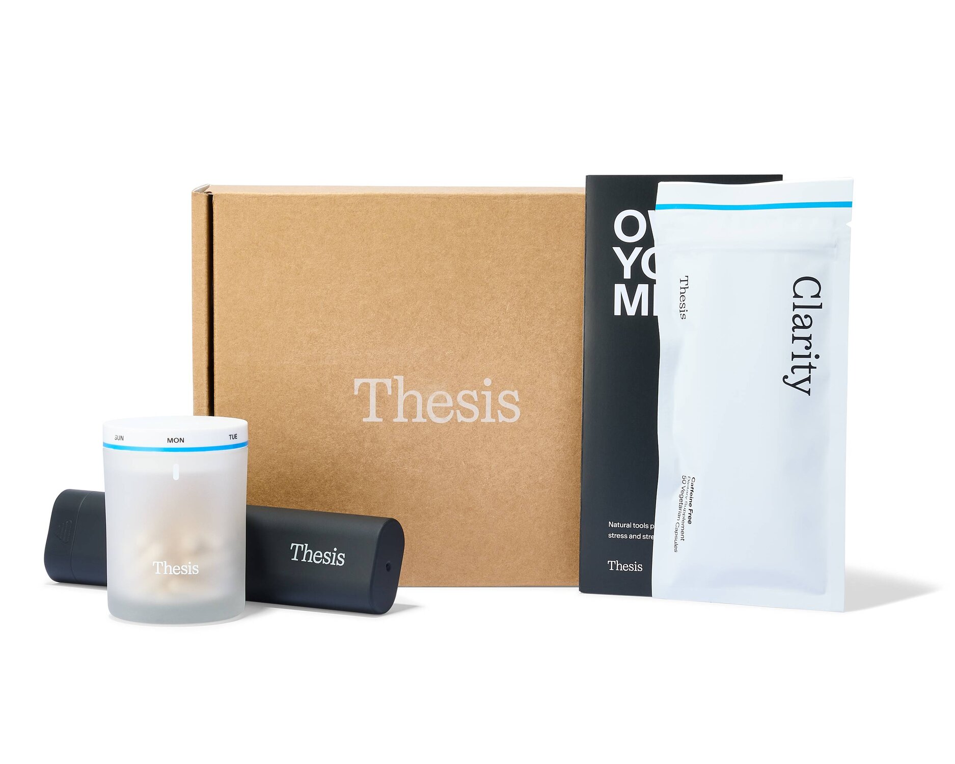Minimalist product flat lay featuring a wellness supplement starter kit. A kraft cardboard box with the “Thesis” logo is centered alongside sleek branded packaging, including a frosted pill container, dark cylindrical cases, and a white pouch labeled “Clarity.” Clean neutral background with modern, premium branding aesthetic.