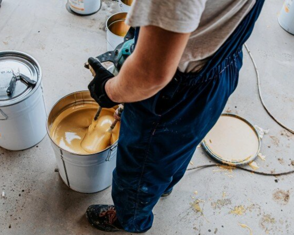 Worker mixing yellow paint