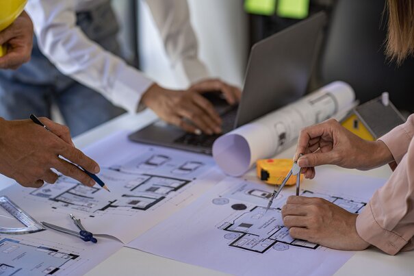 Engineer and architect team meeting, reviewing blueprints