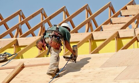 worker applying roof sheet