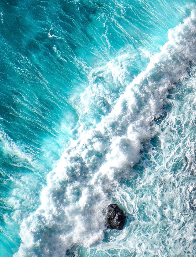 Raw aquamarine stones and crashing ocean waves