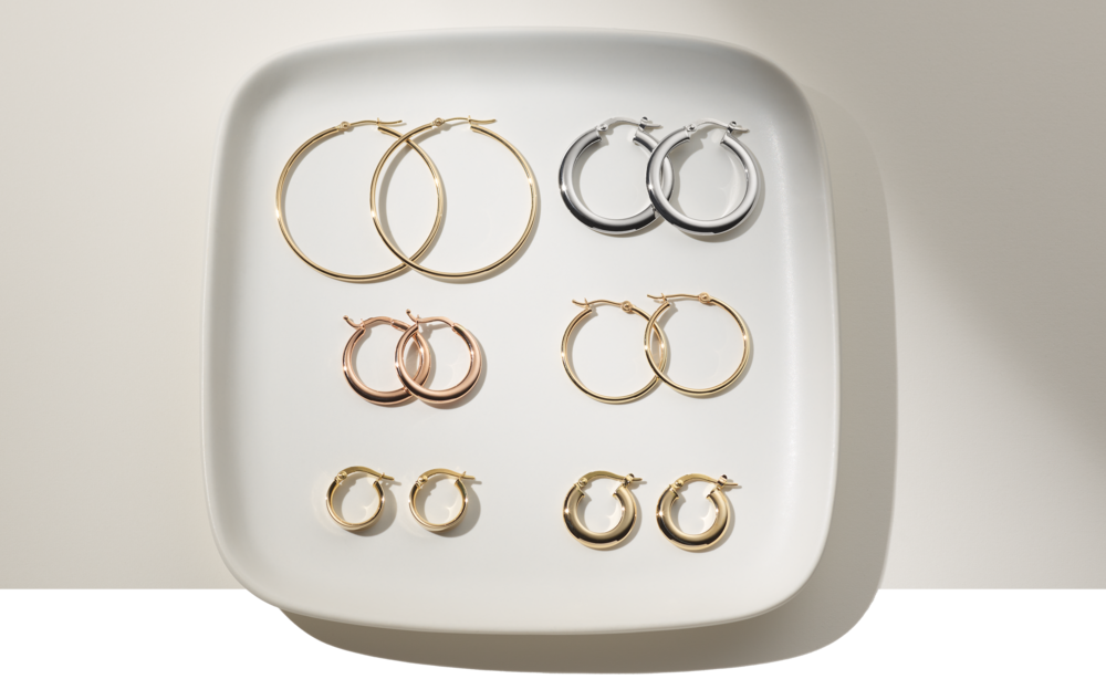 Six pairs of hoop earrings on a plate