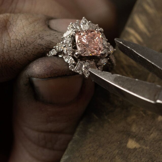 A jeweler setting a diamond center stone into an engagement ring