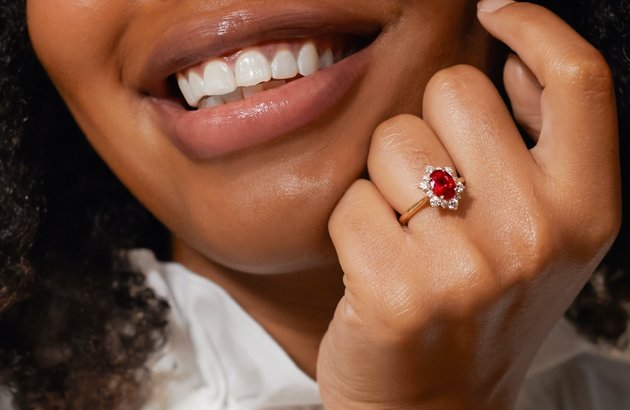 A woman wearing an engagement ring with a colored center stone