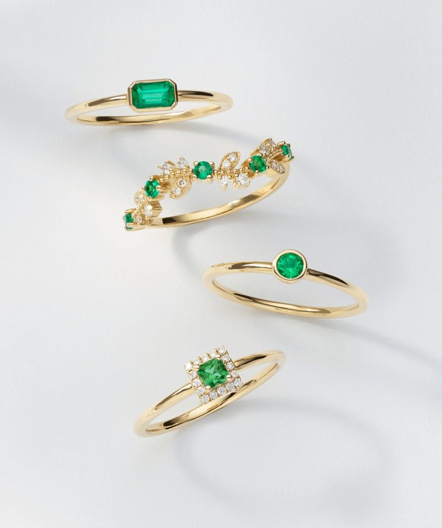 Image: Four exquisite emerald rings crafted in yellow gold. Each ring showcases a vibrant green emerald gemstone set within a beautiful yellow gold band, creating a stunning and elegant jewelry collection.