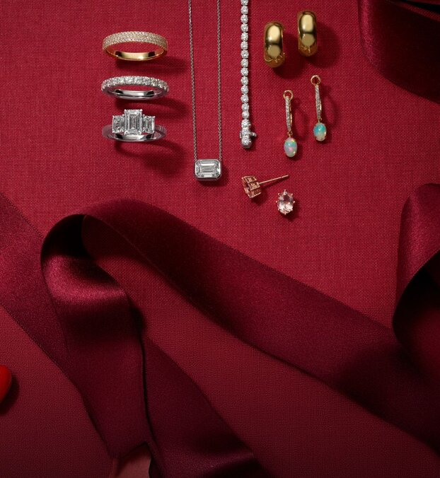 A collection of holiday jewelry on a red background