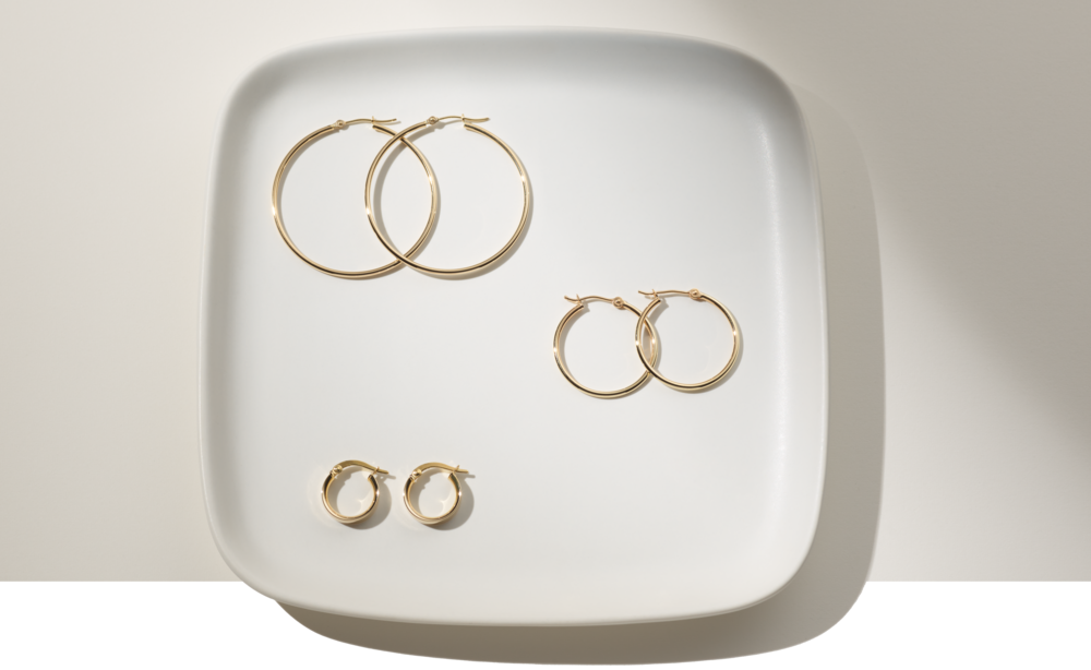 Three pairs of hoop earrings on a plate