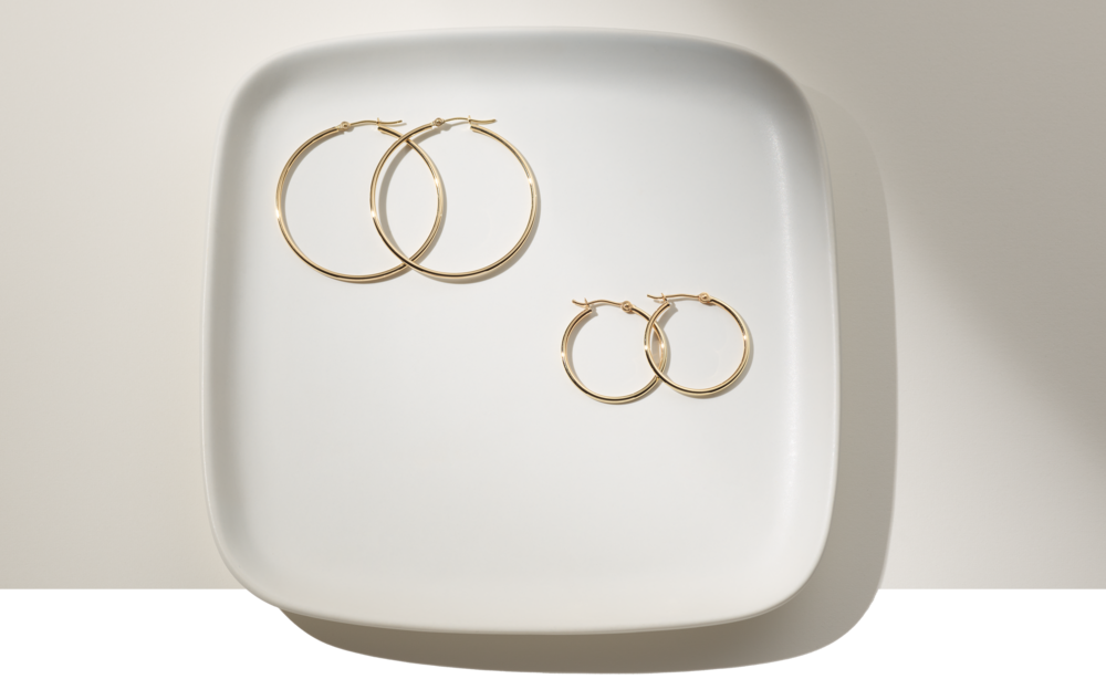 Two pairs of hoop earrings on a plate