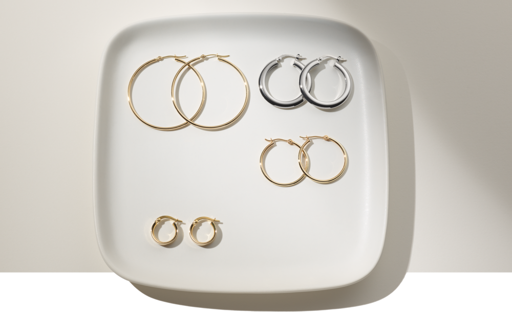 Four pairs of hoop earrings on a plate