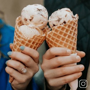 Two hands holding ice cream cones
