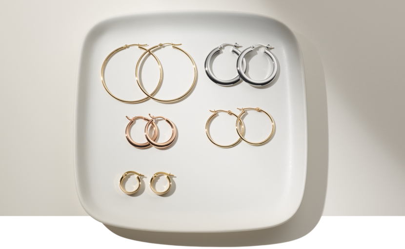 Five pairs of hoop earrings on a plate