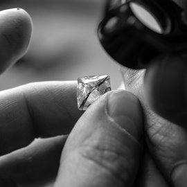 A jeweler examining a rought cut diamond
