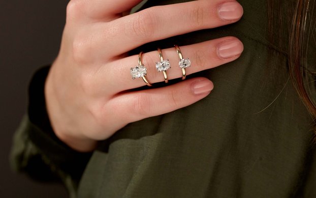 A woman's hand with three solitaire engagement rings