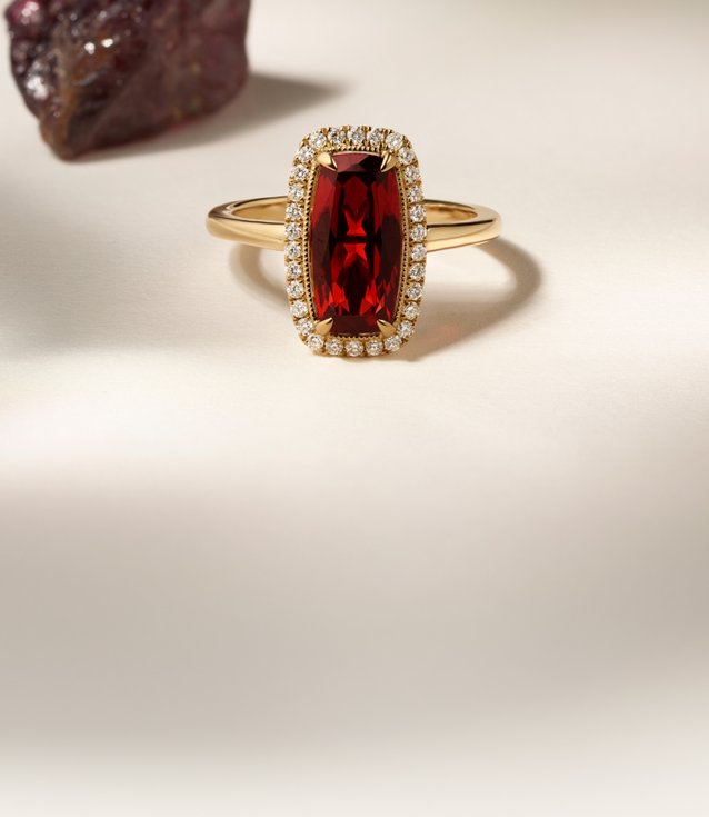 A garnet and diamond fashion ring with a raw garnet in the background