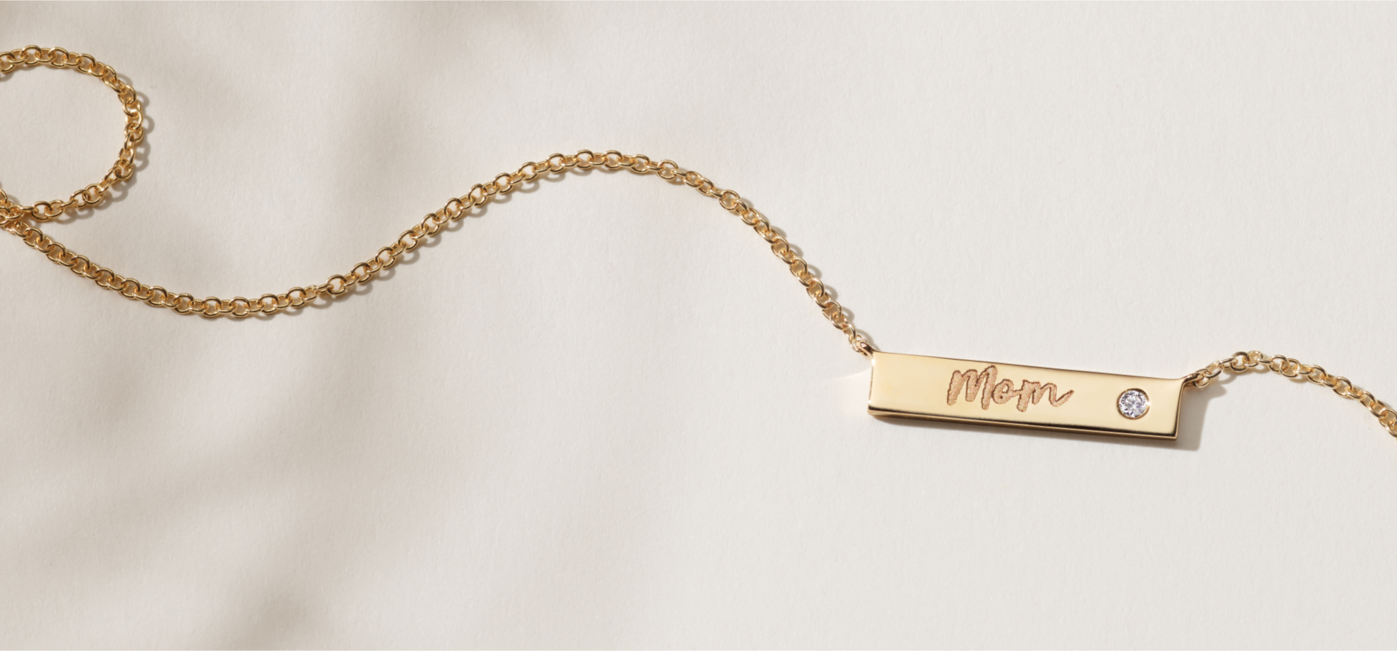 An engraved bar necklace with a single diamond