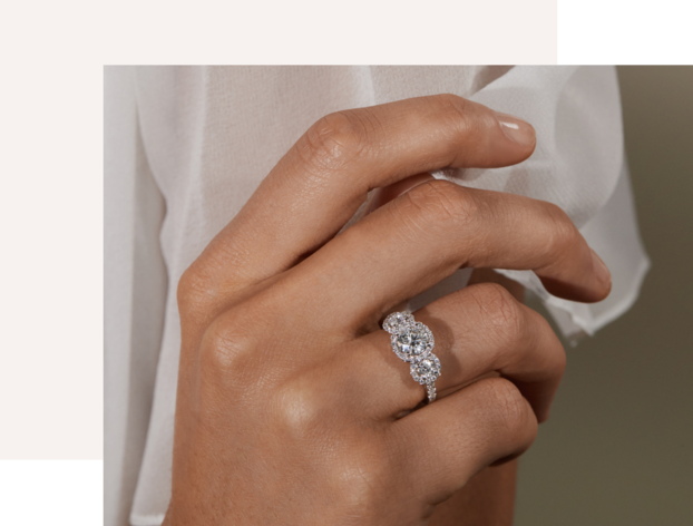 A woman's hand wearing a diamond engagement ring