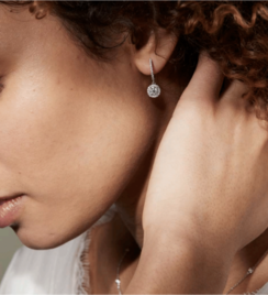 A woman wearing diamond hoop earrings