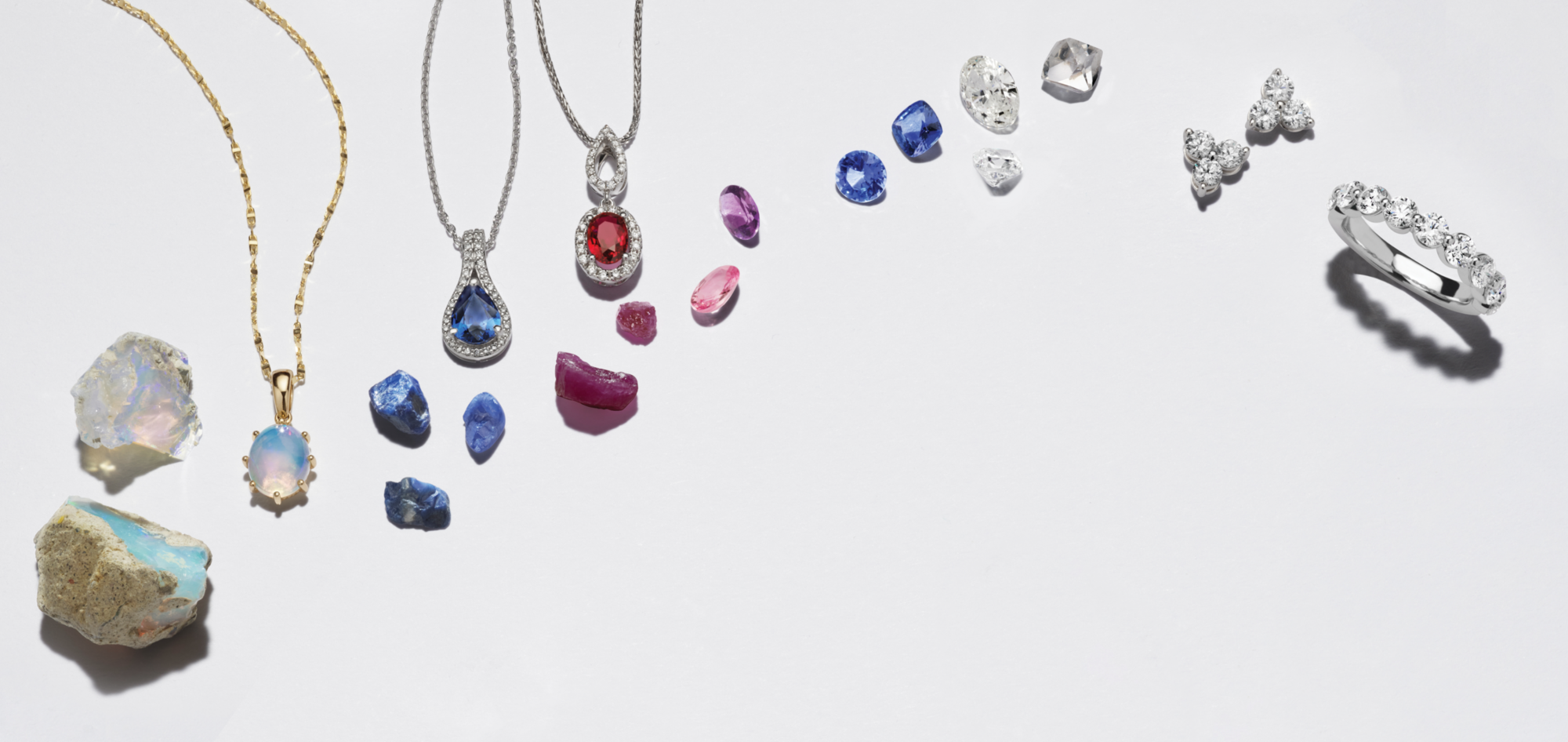 A collection of gemstone jewelry with raw gemstones