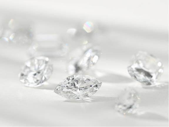 A raw uncut diamond next to a finished cut round diamond