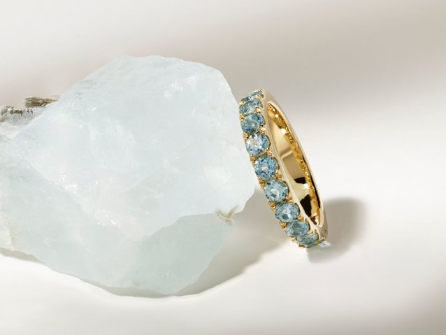 image of raw aquamarine stone with an aquamarine wedding band