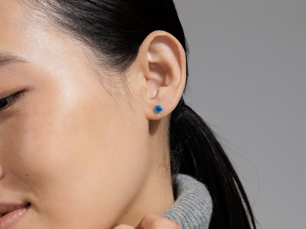 A woman wearing london blue topaz fashion stud earrings