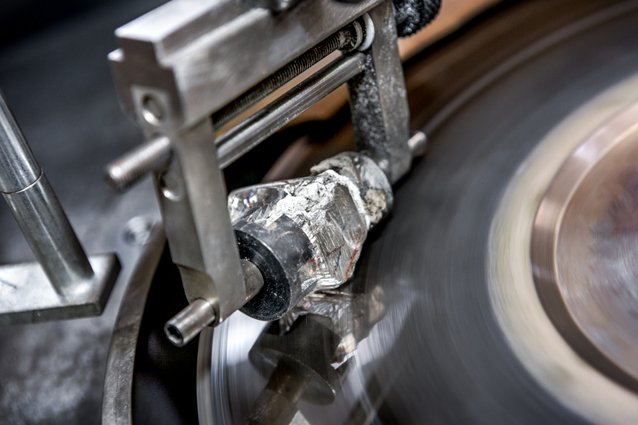 A raw diamond being cut on a cutting wheel