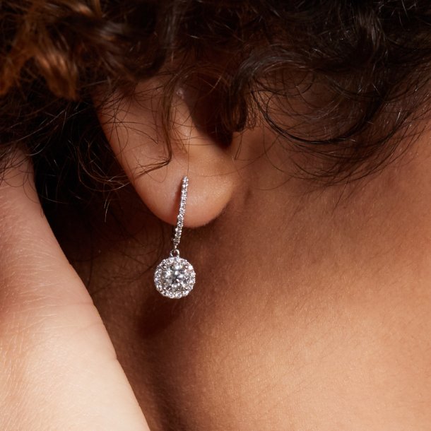 A woman wearing a pair of diamond fashion earrings
