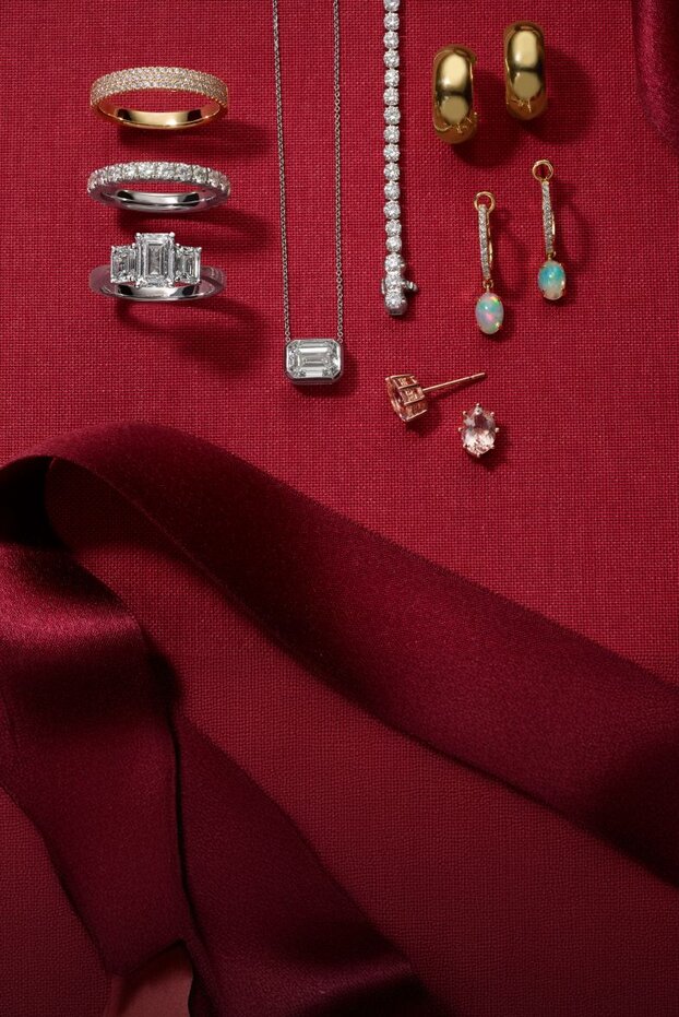 A collection of holiday jewelry on a red background