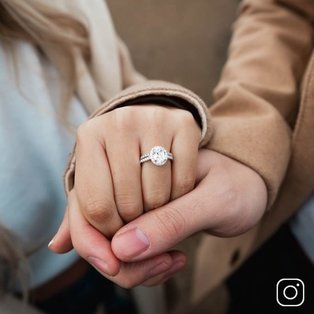 An engaged couple's hands holding each other
