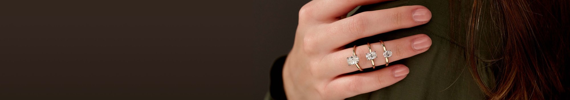 A woman's hand with three solitaire engagement rings