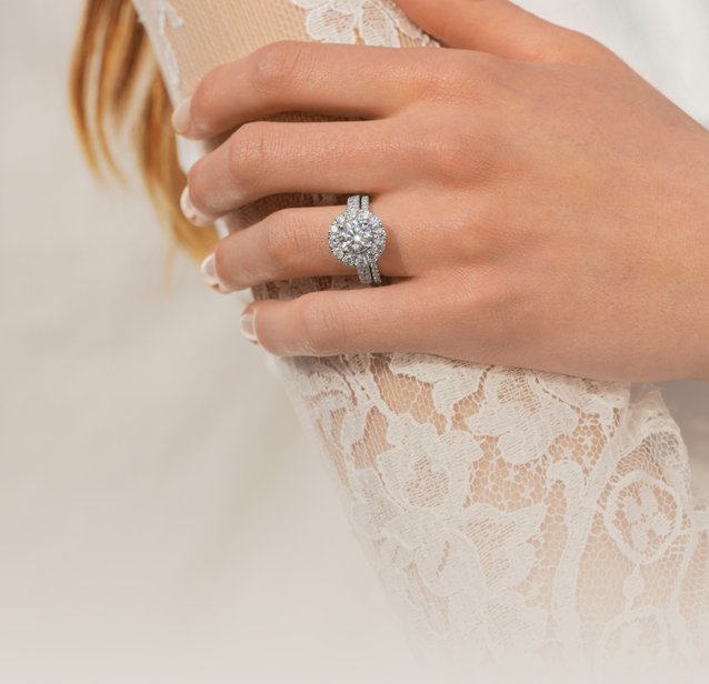 A woman wearing a diamond engagement ring and wedding band