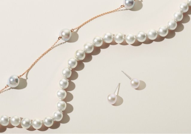A string of pearls, a yellow chain with pearl accents, and a pair of pearl studs