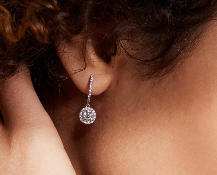 A woman wearing a pair of diamond fashion earrings