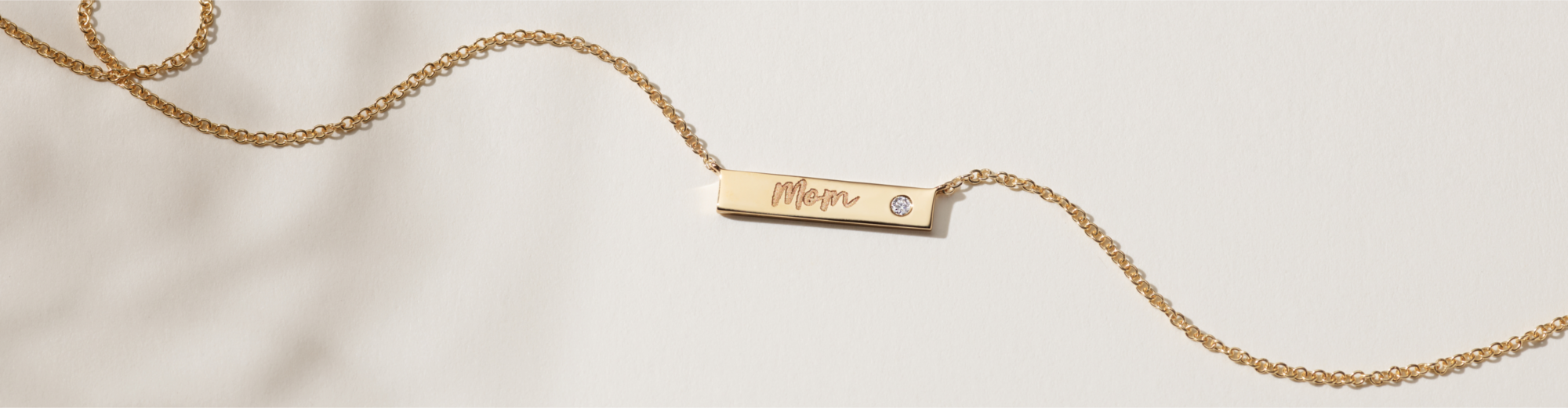 An engraved bar necklace with a single diamond