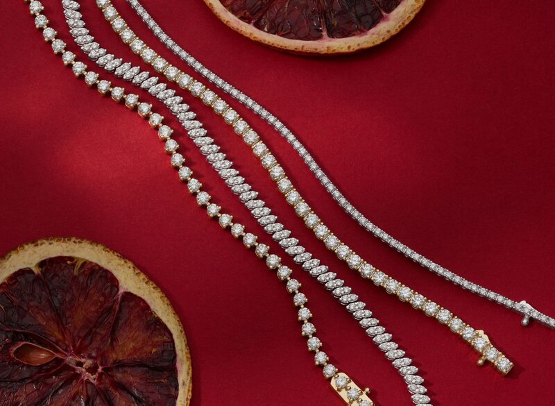 Four diamond tennis bracelets on a red background