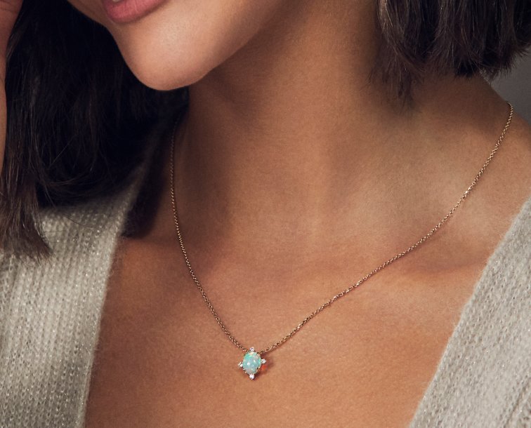 A woman wearing an opal fashion pendant