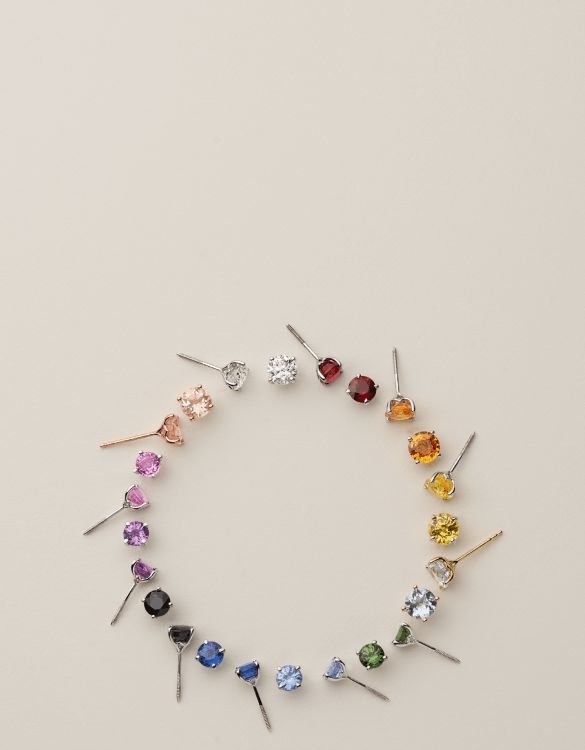 A circle of colorful gemstone stud earrings