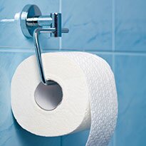 A toilet paper roll installed on blue tile.