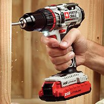 A cordless power drill being used on framing.