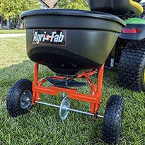 A spreader being used on a lawn.