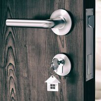 A door handle with a key inserted into the lock below.