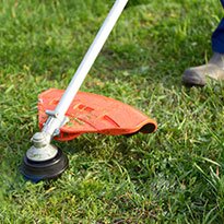 A trimmer being used on a lawn.