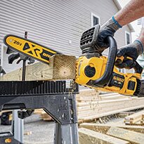 A chainsaw being used to cut lumber.